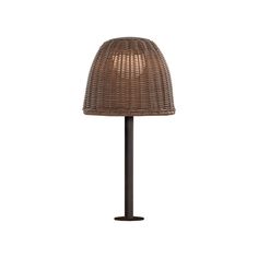 a lamp that is sitting on top of a table with a brown base and wicker shade