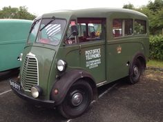 an old green truck parked in a parking lot