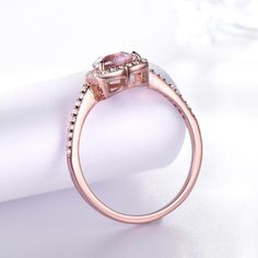 a pink diamond ring sitting on top of a white napkin