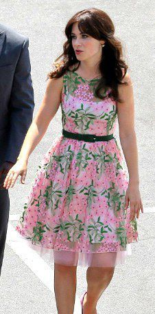 a woman in a pink dress walking next to a man