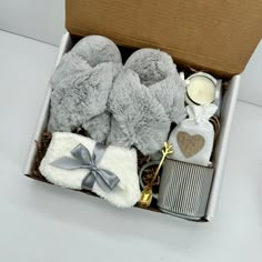 a gift box with two teddy bears, a candle and some other items in it