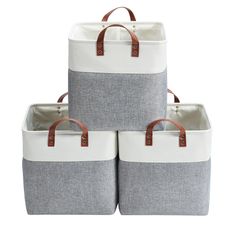 three grey and white storage baskets stacked on top of each other with brown leather handles