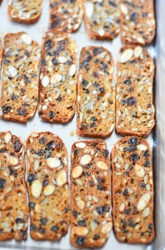 there are many pieces of bread with nuts on it in the pan, ready to be baked