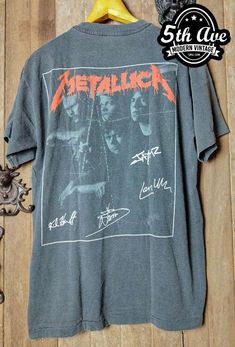 metallic t - shirt with the band's name on it and other metal items