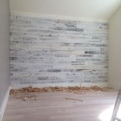 an empty room with wood flooring and a ladder in the corner next to it