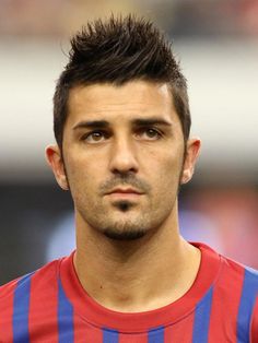 a soccer player is standing in front of the camera with his head turned to the side