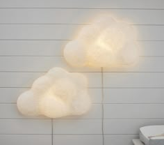 two lights that are on the side of a wall next to each other and one is shaped like a cloud