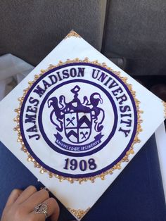 a person holding up a white and blue graduation cap