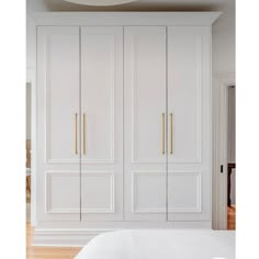 a bedroom with white closets and wood floors