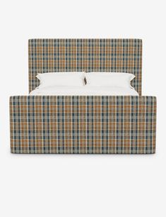 a bed with a plaid headboard and pillows