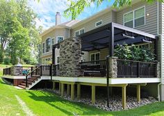 a house with a deck and stone wall