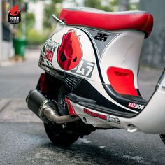 a motor scooter parked on the street in front of a building with red accents