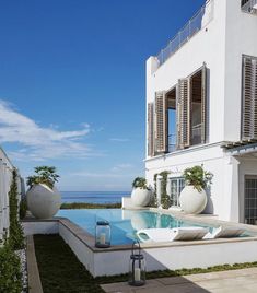 an outdoor swimming pool next to a white building