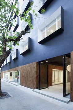 an apartment building with large windows on the side of it's sides and doors open to let in light