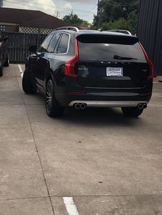 the back end of a black volvo suv parked in a parking lot