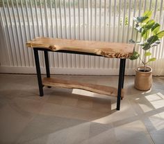 a wooden bench sitting next to a potted plant