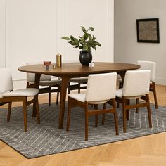 a dining room table with chairs and a potted plant on top of the table