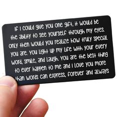 a person holding up a black card with white writing on it