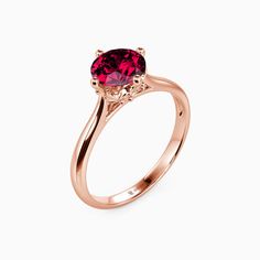 a rose gold ring with a pink tourmaline stone in the center, on a white background