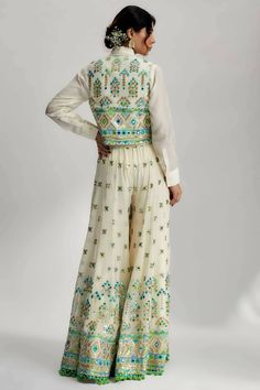 Introducing the exquisite amara jacket set with flared pants, a stunning ensemble that combines traditional craftsmanship with contemporary design. This ensemble features intricate mirror work, pompoms and tassels, along with detailed hand and machine embroidery, making it a true work of art. Intricate Mirror, Mirror Work Embroidery, Kantha Embroidery, Flared Pants, Mirror Work, Flare Pants, Embroidery Machine, Contemporary Design, Machine Embroidery