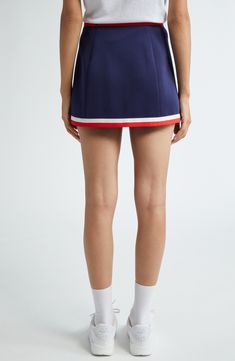 Sporty stripes highlight the waist of this preppy skirt boasting logo branding and comfortable stretch. Pull-on style 95% polyester, 5% spandex Dry clean or machine wash, line dry Imported Asian & Pacific Islander Owned/Founded Navy Fitted Sporty Skort, Sporty Fitted Navy Skort, Sporty Short Pleated Skirt, Sporty Mini Length Lined Tennis Skirt, Sporty Mini Length Tennis Skirt With Lining, Sporty Elastane Mini Skirt For Spring, Sporty Spring Mini Skirt In Elastane, Sporty Mini Length Skort With Lined Skirt, Sporty Mini Skort With Lined Skirt