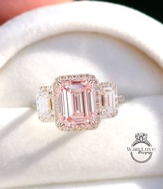 a pink diamond ring with three baguettes in it