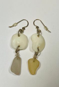 "Sea glass lucky stone dangle earrings. One is lavender and the other one is a beige. The lucky stones are an ivory like stone (inner ear bone of a sheep head fish). They measure 2 1/2\" length, I used twisted silver plated jump rings for the connectors. The ear wire is also silver plated with plastic backings.  Awesome gift idea for the upcycling, ecofriendly, beach lover in your life.  Perfect for a beach wedding! Check out my other items at www.etsy.com/shop/pierbeachglass My sun catchers hav Cream Jewelry With Matching Earrings For Gift, Cream Dangle Earrings Nickel Free, Cream Earrings With Ear Wire For Gifts, Nickel Free Cream Dangle Earrings, Nickel Free Cream Jewelry As Gift, Cream Dangle Jewelry For Gifts, Nickel-free Cream Jewelry For Gifts, Handmade White Glass Jewelry, White Hypoallergenic Beach Jewelry