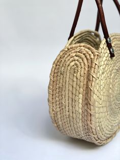 Sustainably Handwoven Straw Circle Bag The Mia Straw Circle Bag is lightweight and durable. This small-size bag will hold all of your essential items. It's the perfect bag for cruising around town. These bags are individually hand-woven with sustainable palm leaves and have naturally tanned leather handles. Thoughtfully designed and ethically made by artisans in Guerrero, Mexico, in a fair trade environment. Each bag is unique and may vary in size, and color, and may have small imperfections. De Eco-friendly Palm Leaf Bag With Open Weave, Eco-friendly Shoulder Bag With Open Weave For Everyday Use, Natural Palm Leaf Beach Bag For Travel, Eco-friendly Woven Leather Bucket Bag, Eco-friendly Palm Leaf Crochet Bag For Travel, Eco-friendly Crochet Palm Leaf Bag For Travel, Eco-friendly Crochet Bag With Woven Leather, Eco-friendly Natural Woven Leather Bucket Bag, Summer Bag In Woven Leather For Everyday Use