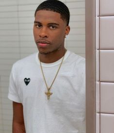 a young man wearing a white t - shirt with a cross on it's chest