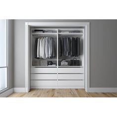 an open white closet with clothes hanging on the doors and drawers in front of it