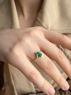 a woman's hand with a green ring on it