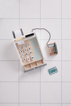 an overhead view of a calculator and phone on a white tiled floor,