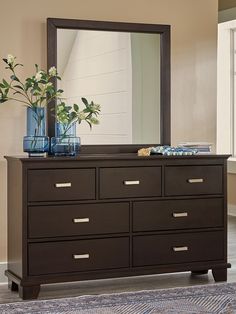 a dresser with a mirror and vases on it