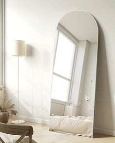 a large mirror sitting on top of a wooden floor next to a chair and table