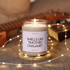 a candle sitting on top of a table next to a guitar