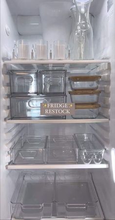 an open refrigerator filled with lots of clear containers and plastic containers on the bottom shelf