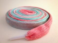 a roll of crocheted fabric next to a pink and blue object