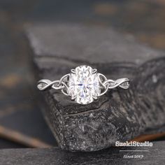 a white diamond ring sitting on top of a rock