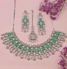 Embrace the feeling of elegance with our Fariba Necklace Set, a must-have from our Royal Heritage collection that combines luxury and grace. Carefully crafted, this stunning necklace set embodies the perfect blend of American chic and Indian artistry. The dazzling colors of the stones effortlessly blend together, adding a touch of opulence to any outfit. From its refined elegance to its cross-cultural charm, this set makes a statement of timeless beauty for every occasion. Handcrafted Metal: Metal Alloy Necklace Set includes necklace, earrings & headpiece Stone: Pearls, Premium American Diamond Stones (faux) Size: One Size Fits All, Adjustable Earrings: L-16CM Weight: 180 grams Made to Order: 2 Week Delivery Time Elegant Silver Kundan Necklace Hand Set, Festive Luxury Jewelry Sets With Elegant Design, Elegant Crystal Necklaces With Stone Setting, Opulent Hand Set Necklace For Gift, Elegant Festive Gemstone Jewelry Sets, Elegant Bridal Necklace With Stone Setting, Luxury Wedding Jewelry Sets With Gemstones, Luxury Silver Kundan Necklace With Elegant Design, Luxury Necklace With Stones For Celebration