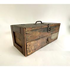 an old wooden box sitting on top of a white table