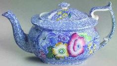 a blue tea pot with flowers painted on it