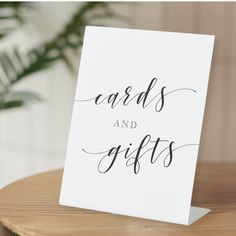 a card with the words cards and gifts on it sitting on a table next to a potted plant