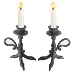 two black candle holders with white candles on them