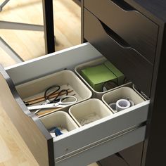 an open drawer with scissors and other items in it