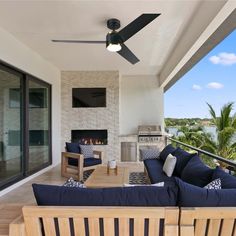 an outdoor living area with couches, table and ceiling fan