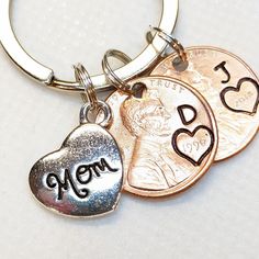 three different types of coins on a keychain with the word mom written on it