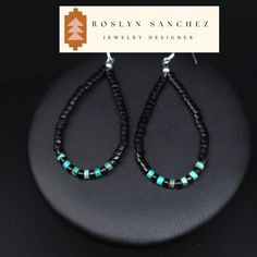 This is a pair of natural jet and turquoise heishi earrings. These earrings match a lot of our jet necklaces but are also great on their own.  A very soft material, Acoma jet is the most commonly found jet in Native American jewelry in the Southwest. It holds many of the same properties as that of jets from other origins, however it often times can show more characteristics of the wood it formed from. *2 3/4" X 1" which includes the earring hooks *natural jet heishi & turquoise heishi *sterling silver hooks A Living Stone All Native Americans believe that the earth is living and all things are precious. Turquoise is no exception, representing life, and is highly revered because of its color-changing properties. Factors such as the environment, light, dust, and skin acidity all play a role Artisan Black Jewelry With Ear Wire, Southwestern Style Black Beads Jewelry For Gift, Southwestern Style Black Bead Jewelry For Gifts, Southwestern Style Jewelry With Black Beads For Gift, Southwestern Black Sterling Silver Jewelry, Black Southwestern Dangle Earrings, Southwestern Black Beaded Dangle Earrings, Adjustable Southwestern Black Earrings, Southwestern Black Beaded Earrings For Gift