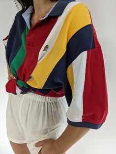 Bright & colorful striped polo by Tommy Hilfiger from the 90s. Polo has a collared neckline with button closures, short sleeves and a signature embroidered crest at the front. Tag reads Tommy Hilfiger A couple very faint darkened spots at the front lower & some speckled discoloration at the end of the left sleeve. Spring Striped Polo Shirt, Striped Preppy Polo Shirt, Preppy Striped Polo Shirt, Retro Short Sleeve Polo Shirt With Striped Collar, Spring Polo Shirt With Contrast Stripes, Retro Polo Collar Top With Striped Detail, Retro Polo Collar Top With Stripes, Casual Multicolor Polo Shirt With Striped Collar, Preppy Striped Polo Collar Top