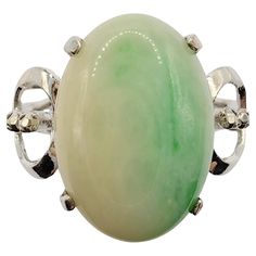 Introducing our exquisite Vintage Solitaire White & Green Jade Ring in White Gold, a captivating piece that seamlessly combines the elegance of white gold with the allure of a stunning cabochon cut jade gemstone. This unique ring showcases a remarkable 13.40mm x 9.40mm cabochon cut jade, set in a lustrous white gold band. The focal point of this ring is the mesmerizing cabochon cut jade gemstone. Known for its smooth, rounded surface and captivating color, the jade exhibits a beautiful blend of Fine Jewelry In Platinum With Cabochon, Fine Jewelry Platinum Cabochon, Elegant White Gold Cabochon Emerald Ring, Exquisite Jade Jewelry For Formal Occasions, Elegant White Gold Emerald Cabochon Ring, White Gold Emerald Ring With Platinum, Fine Jade Jewelry For Formal Occasions, White Gold Emerald Ring With Polished Platinum Finish, Elegant White Gold Cabochon Rings