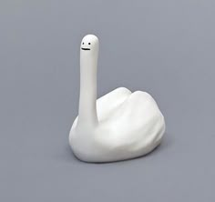 a white swan statue sitting on top of a gray floor